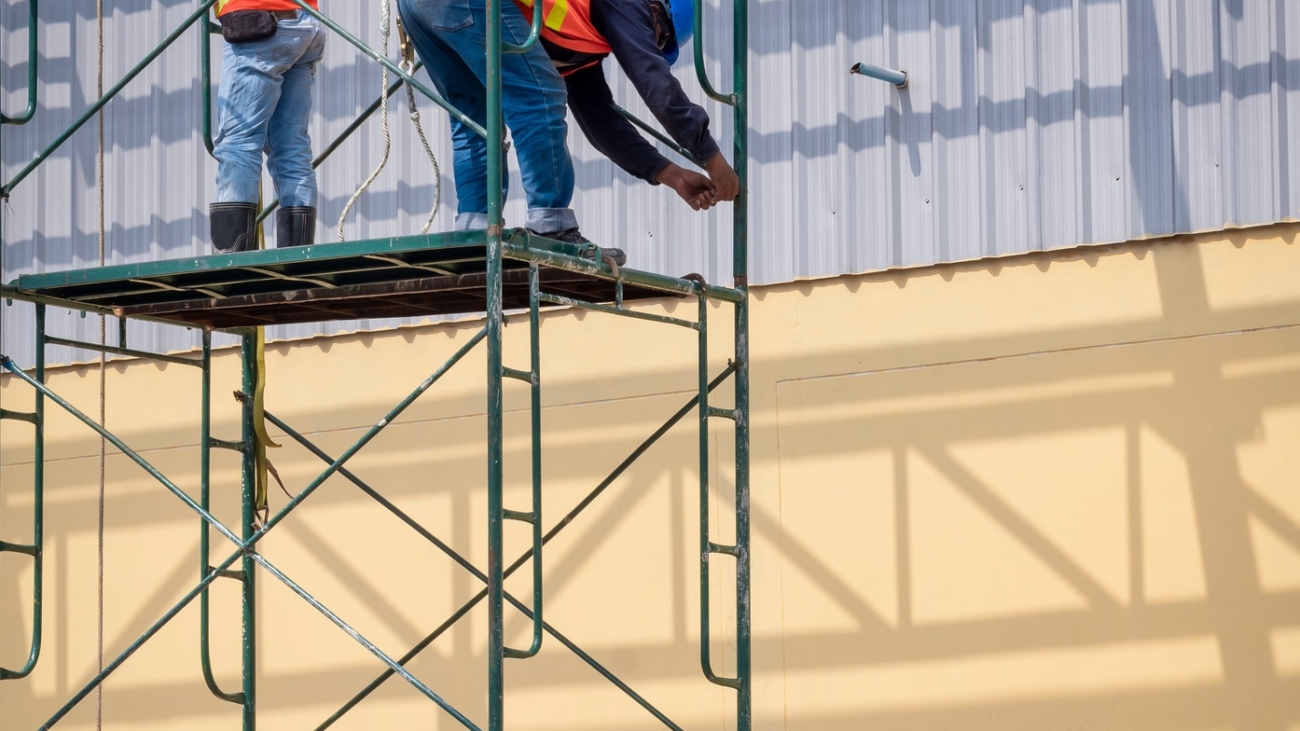 2-construction-workers-installing-high-scaffolding-for-construction-of-industrial-building-structure.jpg