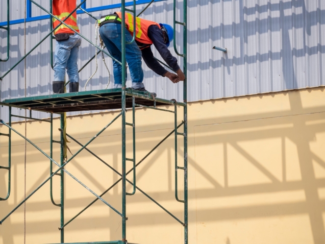 2-construction-workers-installing-high-scaffolding-for-construction-of-industrial-building-structure.jpg